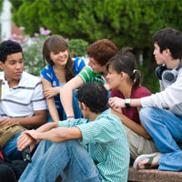 Mehrere Jugendliche sitzen zusammen und unterhalten sich.